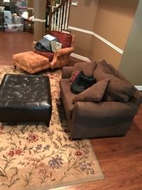 black leather ottoman, area rug, brown suede chair has been sold
