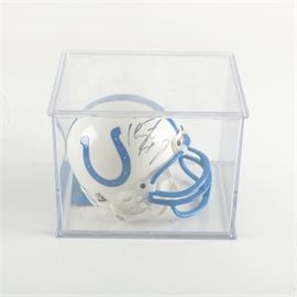 Peyton Manning Autographed Miniature Helmet: A Peyton Manning autographed Indianapolis Colts miniature helmet in case. Includes a Riddell miniature helmet in the Colts’ familiar blue and white pattern, with the autograph of fourteen-time Pro Bowler Peyton Manning in black on the crown. The helmet is presented in a clear Plexiglas display case.