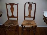 Description of chair to the right: The American Queen Anne Maple Rush Seat-Side Chair, made in New England, probably New Hampshire. Shaped, rounded crest continues to stiles centering solid vasiform splat; flaring feet; vigorously block turned legs connected by baluster-turned stretcher. Later rush seat. H: 40 1/2"; Seat H: 17 1/2"; D: 13 1/2"; W: 19"
Chair to the left:AMERICAN QUEEN ANNE/CHIPPENDALE TRANSITIONAL MAPLE RUSH SEAT SIDE CHAIR. Vasiform splat below bowed crest; baluster-turned stretcher; H: 40.25", Seat H: 17.25"; D: 14"; W: 20"