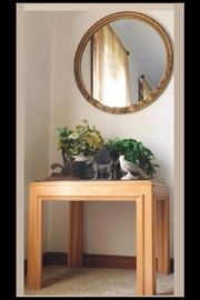  27 inch round mirror with  25 inch by 21 inch by 21 inch table with collection of cast iron  including door stoppers:  scotties, squirrel and bird