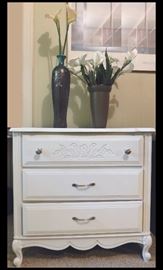 White three-drawer dresser with vases and silk flowers