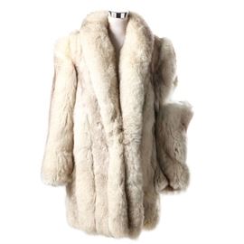 Blue Fox Fur Stroller Jacket: A blue fox fur stroller jacket. The jacket has a shawl collar and front, two exterior pockets, full length sleeves, furrier hook closure and gray floral lining. The right sleeve needs minor repairs as it has detached from the shoulder. Tag to interior reads, “UnitedStatesFur.com”