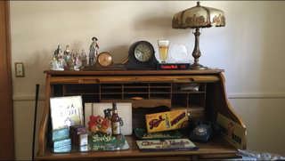 Mt Airy roll top desk, tiffany lamp, variety of beer signs, and clocks