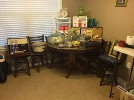 Round table with 5 chairs and more kitchen items.