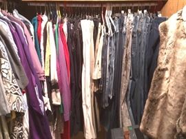MBR closet - full of both men's and women's clothing items - including some men's suits and sport jackets