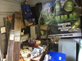 Posters galore, letters in box, Superman, TV and desk.