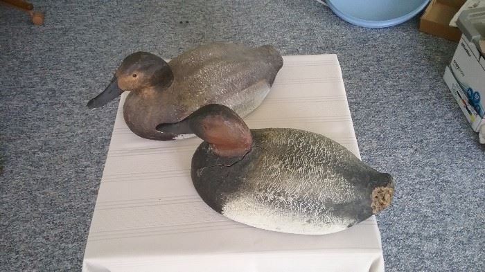 vintage duck decoys with artist name printed on bottom along with date of repainting. 