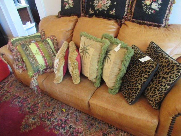 Decorator pillows on thick leather couch/sofa with large nailhead trim