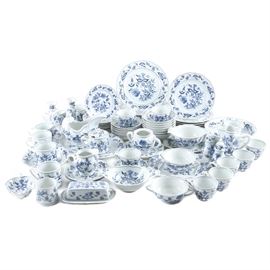 Blue Danube China Set: A large assortment of Blue Danube china. The collection includes over sixty two pieces featuring scalloped edges and a transfer-printed floral motif in blue. Each is marked Blue Danube and Japan to the underside. The collection includes seven dinner plates, eight salad plates, eight dessert plates, a pair of candlesticks, seven coffee mugs, eight teacups, a salt and pepper shaker set, a sugar bowl and creamer set, two pitchers, seven cereal bowls, a gravy boat, a butter dish, two double handled bowls, a jelly jar, a leaf-shaped dish, a small casserole, a serving bowl and one serving platter.