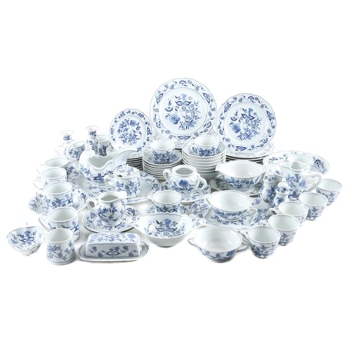 Blue Danube China Set: A large assortment of Blue Danube china. The collection includes over sixty two pieces featuring scalloped edges and a transfer-printed floral motif in blue. Each is marked Blue Danube and Japan to the underside. The collection includes seven dinner plates, eight salad plates, eight dessert plates, a pair of candlesticks, seven coffee mugs, eight teacups, a salt and pepper shaker set, a sugar bowl and creamer set, two pitchers, seven cereal bowls, a gravy boat, a butter dish, two double handled bowls, a jelly jar, a leaf-shaped dish, a small casserole, a serving bowl and one serving platter.