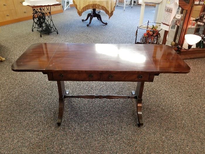 Vintage "BAKER" brand table. Has drop leafs on both ends, and casters.