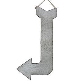 Large Galvanized Steel Arrow Sign: A large galvanized steel arrow sign. The piece features unfinished galvanized steel construction with copper tone trim to the edges of the piece. It is ready to hang with a length of rope noted at the top. It is unmarked.