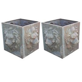 Pair of Green Cast Iron Lion Planters: A pair of cast iron planter boxes. This pair of boxes have a lions face on each side that is dimensional. They are in the shape of a square box and have a gray over brown color.