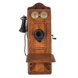 Antique Kellogg Hand-Crank Wall Phone: An antique Kellogg oak and brass hand-crank wall telephone. This early 20th century phone is incised to the mouthpiece “Kellogg – Chicago, USA / Patd. Nov. 26, 1901.” It is branded “2614” to the lower front cabinet.