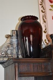 A Ruby Red Glass Vase and "shrink wrapped" ornate Bookends behind
