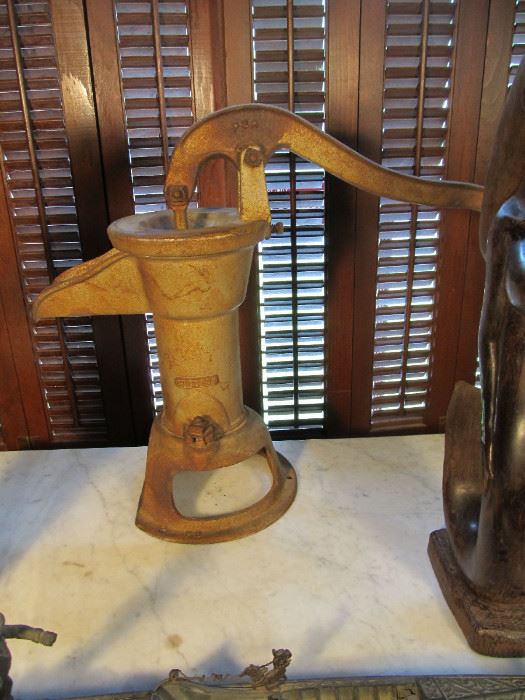 Antique hand operated well pump or indoor pump. A trace of the mermaids tail in visable 