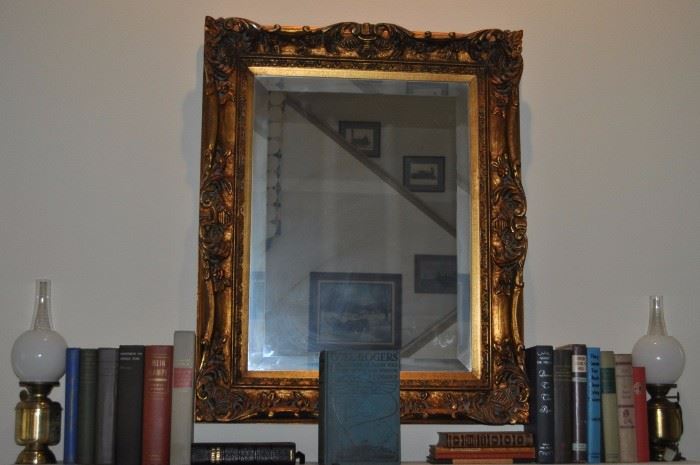 Vintage lamps, vintage/antique books, ornate gold framed beveled mirror