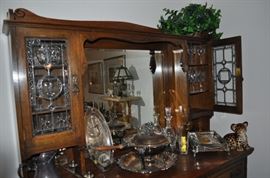 Art Nouveau c. 1905 breakfront leaded glass doors lined drawers beveled mirror, miscellaneous silver serving pieces, Waterford Ashling crystal stemware and decanter, handmade porcelain leopard kitten