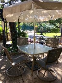 Outdoor table with chairs and umbrella.