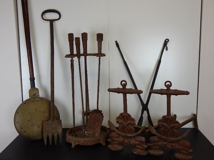 A selection of iron pieces including early nautical andirons and fireplace set, 18th century waffle iron with musical lyre design and coal fork