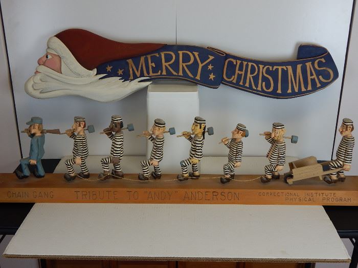 Large (30") Santa/Merry Christmas banner carving by K.N. Ferris  and the Pa folk artist, Elmer Jumpers, "Tribute to Andy Anderson" in which a chain gang is being led by a guard,the only figure not having a big smile. Andy Anderson was a cowboy who went to Hollywood in the 1940's and appeared in a number of western movies but was always a wood carver at heart.