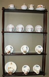 A mahogany shelf with a collection of cups and saucers.