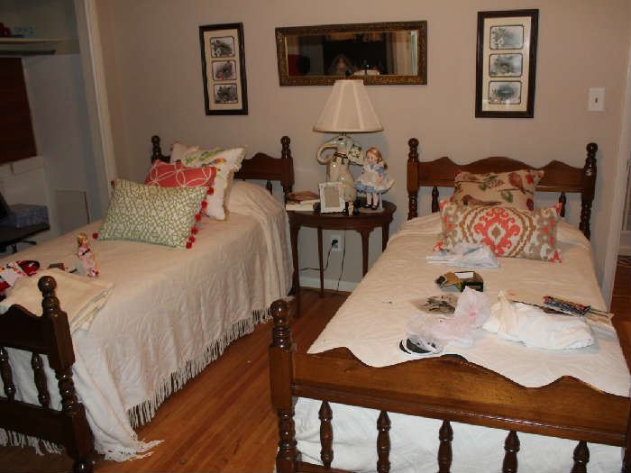 The twin beds with bed spreads and pillows.