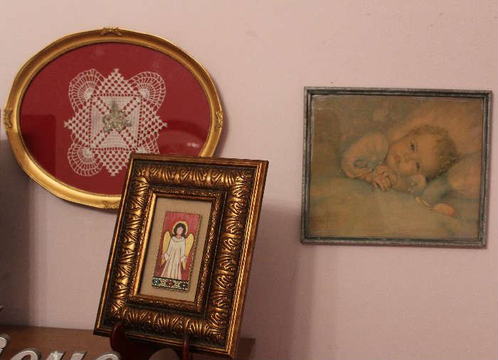 Close-up of the hand painted angel, baby's picture, and the pin and doily in the round antique frame.