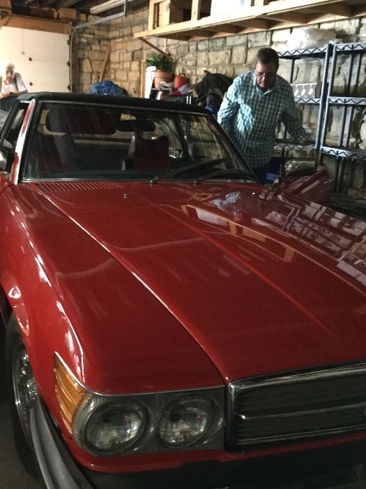 1978 Mercedes 450 SL. Red. Black convertible top. Red and black interior. Seriously cute car 