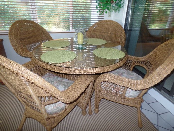 Like new wicker, round  glass top table and 4  arm chairs