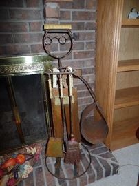 Wrought iron man holding fire tools and log holder