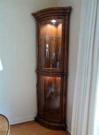 American Furniture Co. solid wood, well made, corner curio cabinet.  Two sections (both lighted), curved glass front and glass shelves.  72" tall.