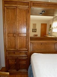 Queen size bed with wall unit headboard - tons of storage! Six cabinets, 2 drawers, 2 pull-out bedside shelves, mirrored back and 2 built-in reading lights.  114" wide, 77" tall, 16" deep.  Made of solid wood.