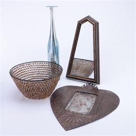Assortment of Mirrors and a Vase: A collection of decorative items. This collection of four items features a glass vase that is tall and slender and is in the style of mercury glass. The collection also includes a wire mesh and brown beaded basket, a tin framed heart shaped mirror, and a accent mirror with five sides.