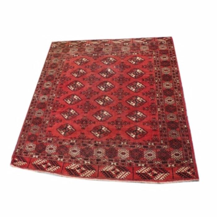 Vintage Hand-Knotted Tekke Bokhara Area Rug: A vintage hand-knotted Tekke Bokhara area rug. This wool rug is rendered in a palette of red, black, and ivory. It begins with three vertical rows of Tekke medallions interspersed with smaller Chemche medallions on a red field. Framing the field are six geometric box borders and two horizontal panels, at the top and bottom of the field, feauring dyrnak hooked diamond medallions. Selvedges are overcast, the rug finishing at each end with short warp fringe. It is unlabeled.