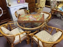 Beautiful rattan, glass-top table and four chairs. Reupholster cushions and paint, if you desire, to make it your own