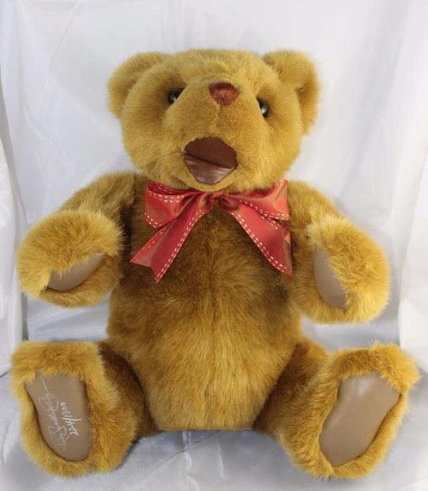 Bustopher - 322. 1992 Gund Signature Collection in  plush caramel/leather-tan. Stands 15" H in  excellent condition. A baby bear that has tan  leather paw pads and an open smiling leather  mouth. Tied around his neck is a reddish-orange bow
