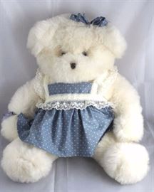 Bridgette - 64. 1989 Plush-white JDawn  Chitner-Bridgewood Bear. Non-jtd. Plump bear  wearing a whit lace trimmed blue pinafore with  hears and matching hair bow. signed on her tag. Size:  16.5" H
