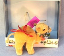 Steiff Dromedary Camel Ornament in beige mohair.   North American Exclusive.  This honey beige camel  is decorated with a harness, complete with bells  and colored tassels.  Ltd. #0931 of 2003. Size:  4.5" H
