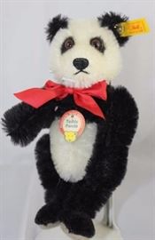 Steiff Teddy Bear - Teddy Panda Mini-96.  Jtd.  black and white mohair bear with flat grey paw  pads.  Wears a yellow elephant historic chest tag,  "Teddy Panda".  Yellow ear tag and red ribbon  neck bow.
