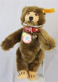 Steiff Teddy Bear - Teddy Baby Mini-92.  Jtd.  brown mohair bear with yellow elephant historic  chest tag, "Teddy Baby".  With yellow ear tag.   Paw pads (flat) are cream flannel.  Wears a  decorated red leather collar with brass bell.

