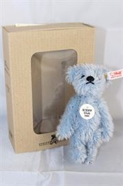 Light Blue Teddy Bear - 1007. Steiff U.S Club 2004  Gift with string plush-light blue mohair. 3.5" H  in excellent condition. Has white ear tag (red  printed) with the button and tag specially sized.  Wears a round chest tag "Steiff Club 2004".  
