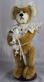 Junie The Bride-206.  Teddy Bear Classic at  Disneyland Convention.  Wears a bridal tulle  headpiece and a small white pearl necklace.  Holds  a bridal bouquet.  Ltd. #1 of 25. Size:  10" H
