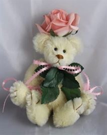 Miss Rosemary-45 Rose Bear.  She wears a pink rose  on her head with the green leaves extending from  her neck down her chest.  She has small pink  ribbon bows tied in several places.  Ltd. #26 of  50.
