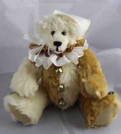 Tabasco-193.  Hump-backed Jester Bear stuffed with  plastic pellets.  Around neck a double ruffle  (bottom-white satin, top-gold metallic) tied with  a white ribbon bow.  White satin jester cap with  gold jingle bells.
