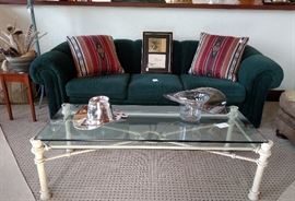 Green upholstered sofa and glass top coffee table
