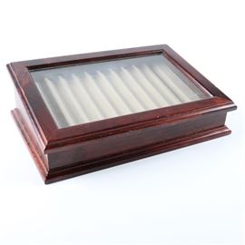 Levenger "Point of View" Pen Display Case in Dark Cherry: A display box by Levenger in the “Point of View” model. This box is constructed of alder with a dark cherry finish and a glass-paneled, hinged door. Its interior is lined in nonreactive suede and has grooved half-inch-wide cradles for holding ten pens at an angle for viewing. It is marked “Levenger, Made in China, QC2” to the verso.