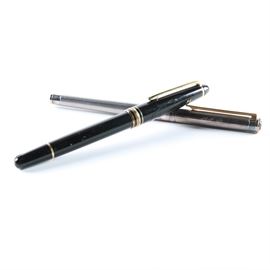 Pair of Montblanc Pens: A pair of Montblanc pens. Pens feature gold accents and ball point tips. The lid for the silver toned pen, has initials engraved into it, which read “ALD.”