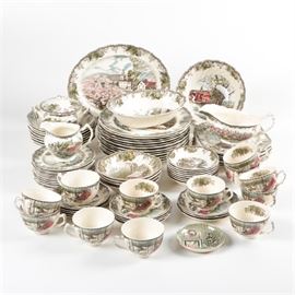 Johnson Brothers "Friendly Village" Tableware: An eighty five piece collection of Friendly Village tableware by Johnson Brothers England. This pattern was manufactured between 1958-2003 and depicts idyllic village scenes with foliate borders. Among the group are dinner plates, bowls, serving pieces and teacups. The pieces are marked to the base with the Johnson Brothers maker’s mark.