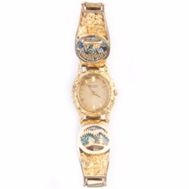 Seiko Wristwatch With 10K Gold, Opal and 22K Alaskan Gold Nugget Overlay: A Seiko wristwatch with 10K bracelet trim, 22K genuine Alaskan gold nugget overlay, and opal and Alaskan gold gold nugget inlay depicting a cabin with trees against the northern lights.